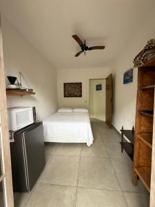 een slaapkamer met een bed en een plafondventilator bij Suites do Félix in Ubatuba