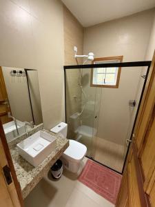een badkamer met een toilet, een wastafel en een douche bij Suites do Félix in Ubatuba