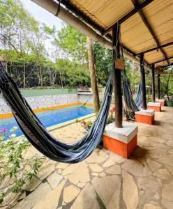 a hammock in a pavilion next to a swimming pool at Vila Pepouze Hostel in Morro de São Paulo +117 photos