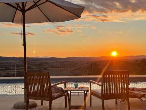 two chairs and an umbrella on a patio with a sunset at Podere Stabbia in Rosennano