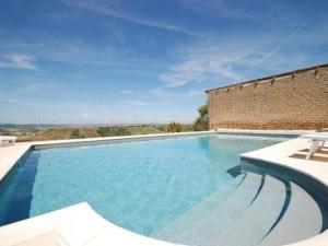 a large blue swimming pool with a brick wall at Podere Stabbia in Rosennano