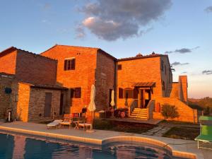 a brick building with a pool in front of it at Podere Stabbia in Rosennano