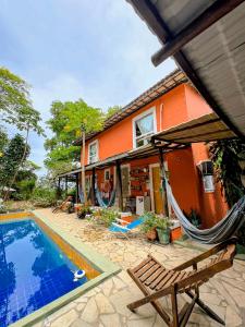 a house with a pool and a hammock next to it at Vila Pepouze Hostel in Morro de São Paulo