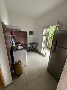 een keuken met een koelkast en een tafel bij Suites do Félix in Ubatuba