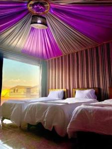 a bedroom with two beds and a purple ceiling at Wadi Rum Salem Muhammad in Wadi Rum