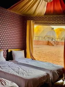 a bedroom with two beds and a window at Wadi Rum Salem Muhammad in Wadi Rum