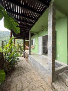 een huis met groene muren en een houten plafond bij Suites do Félix in Ubatuba
