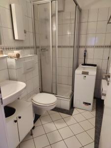 a white bathroom with a toilet and a shower at Wald & Weg in Schmallenberg