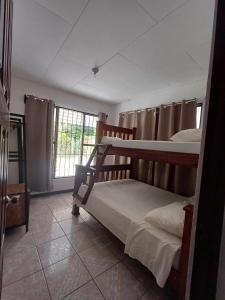 una camera da letto con due letti a castello e una finestra di River House San Jose a Sarapiquí