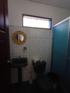 un bagno con un water, un lavandino e una finestra di River House San Jose a Sarapiquí