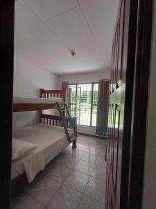 una stanza con due letti a castello e una finestra di River House San Jose a Sarapiquí