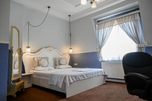 a bedroom with a white bed and a chair at Hotel Green Garden in Shumen +24 photos