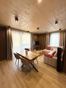 een woonkamer met een tafel en een bank bij Apartmán Forest, Tatranská Štrba in Tatranska Strba