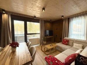 een woonkamer met een bank en een tafel bij Apartmán Forest, Tatranská Štrba in Tatranska Strba