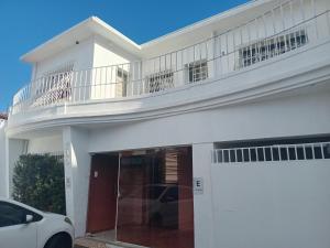 a white house with a balcony on top of it at Capsula Residence Hotel in Marília +7 photos