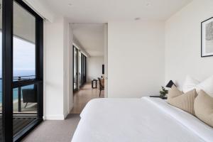 a bedroom with a white bed and a large window at The Outlook in Newcastle