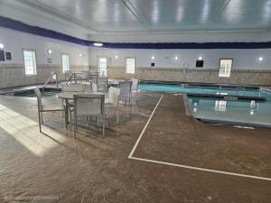 una piscina con tavolo e sedie accanto a una piscina di La Quinta Inn & Suites by Wyndham Minot a Minot