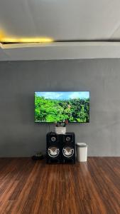a flat screen tv on a wall in a room at Aby's Guest House in Tlekung