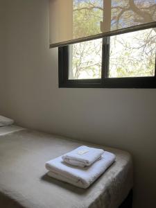 a room with a bed with two towels on it at Las Lomitas in Carpintería