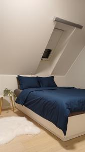 a bed with blue sheets in a white room at Keila Round View Apartment in Keyla