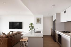 een keuken en een woonkamer met een wastafel en een bank bij The Outlook - 2 bed option in Newcastle +5 foto's