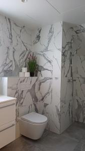 a bathroom with a toilet and a marble wall at Keila Round View Apartment in Keyla
