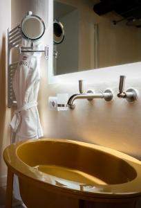 une salle de bains avec un lavabo jaune et un miroir dans l'établissement Locanda Sibilla Luxury Suites, à Tivoli