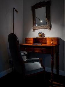 un bureau avec une chaise à côté d'un miroir et d'un miroir dans l'établissement Locanda Sibilla Luxury Suites, à Tivoli