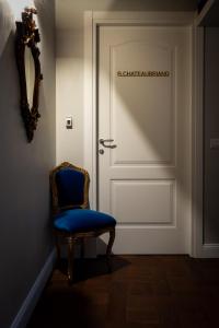 une porte avec une chaise bleue devant dans l'établissement Locanda Sibilla Luxury Suites, à Tivoli