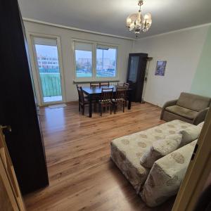 ein Wohnzimmer mit einem Bett und einem Tisch und Stühlen in der Unterkunft Mieszkanie Kapitana Pałaca in Serock