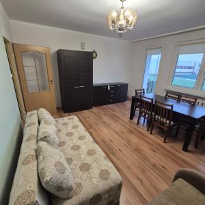ein Wohnzimmer mit einem Sofa und einem Esstisch in der Unterkunft Mieszkanie Kapitana Pałaca in Serock