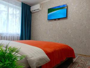 una camera da letto con un letto e una TV a parete di 11 Microragion ad Aqtöbe
