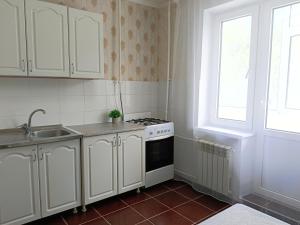 una cucina con armadietti bianchi, piano cottura e finestra di 11 Microragion ad Aqtöbe