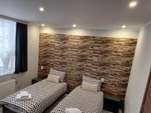 a room with two beds and a brick wall at Stoykite view in Stoykite