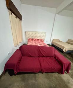 a bedroom with two beds with a red comforter at Sueños de Mar in Mar del Tuyú