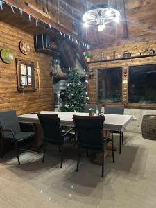 ein Esszimmer mit einem Weihnachtsbaum, einem Tisch und Stühlen in der Unterkunft Kuća za odmor Ema in Gospić