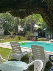 a group of chairs and a table next to a pool at Puerto Sosiego in Gualeguaychú