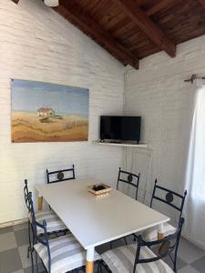 a white table with chairs and a tv on a wall at Puerto Sosiego in Gualeguaychú