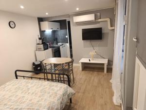 a room with a bed and a table and a kitchen at Studio charmant in Sedan +6 photos