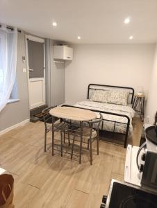 a room with a bed and a table and chairs at Studio charmant in Sedan