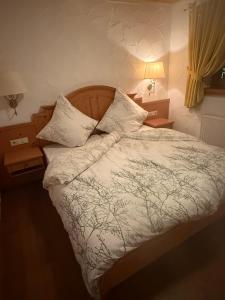 a bedroom with a bed with white sheets and pillows at JOHN'S Pension in Saarwellingen