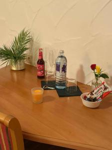 a wooden table with bottles and glasses and a bowl of food at JOHN'S Pension in Saarwellingen +1 photo