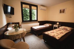 una camera con due letti, un tavolo e un divano di Noclegi a Ruda Śląska