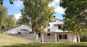 una casa blanca con un coche aparcado delante de ella en Bambù Affittacamere & Residence, en Teramo