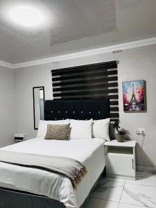 a bedroom with a large bed with a black headboard at 4 at Granada 1 in East London
