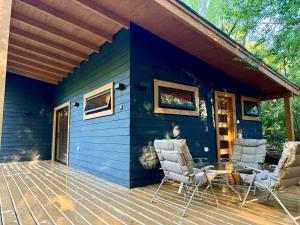 a blue house with two chairs and a table on a deck at Casa Oregon Pucura in Traitraico