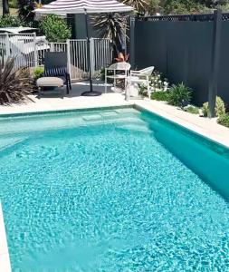une piscine avec de l'eau bleue dans une cour arrière dans l'établissement Courtyard Pool Studio Private Luxe Retreat, à Coal Point