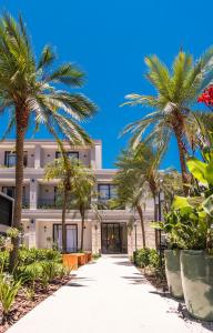 a palm tree lined driveway to a building with palm trees at Solena in Camburi
