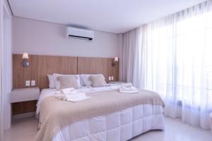 a bedroom with a large bed with towels on it at Solena Hotel in Camburi