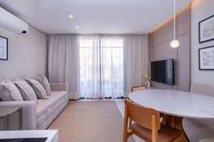 a living room with a couch and a table at Solena in Camburi